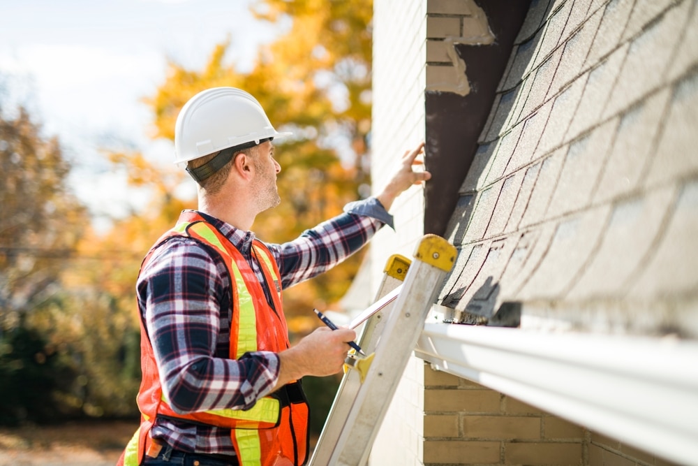 A,Man,With,Hard,Hat,Standing,On,Steps,Inspecting,House