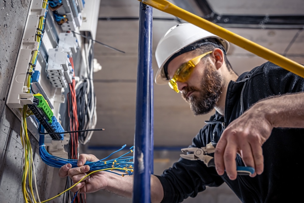 Technician inspecting electrical control panel